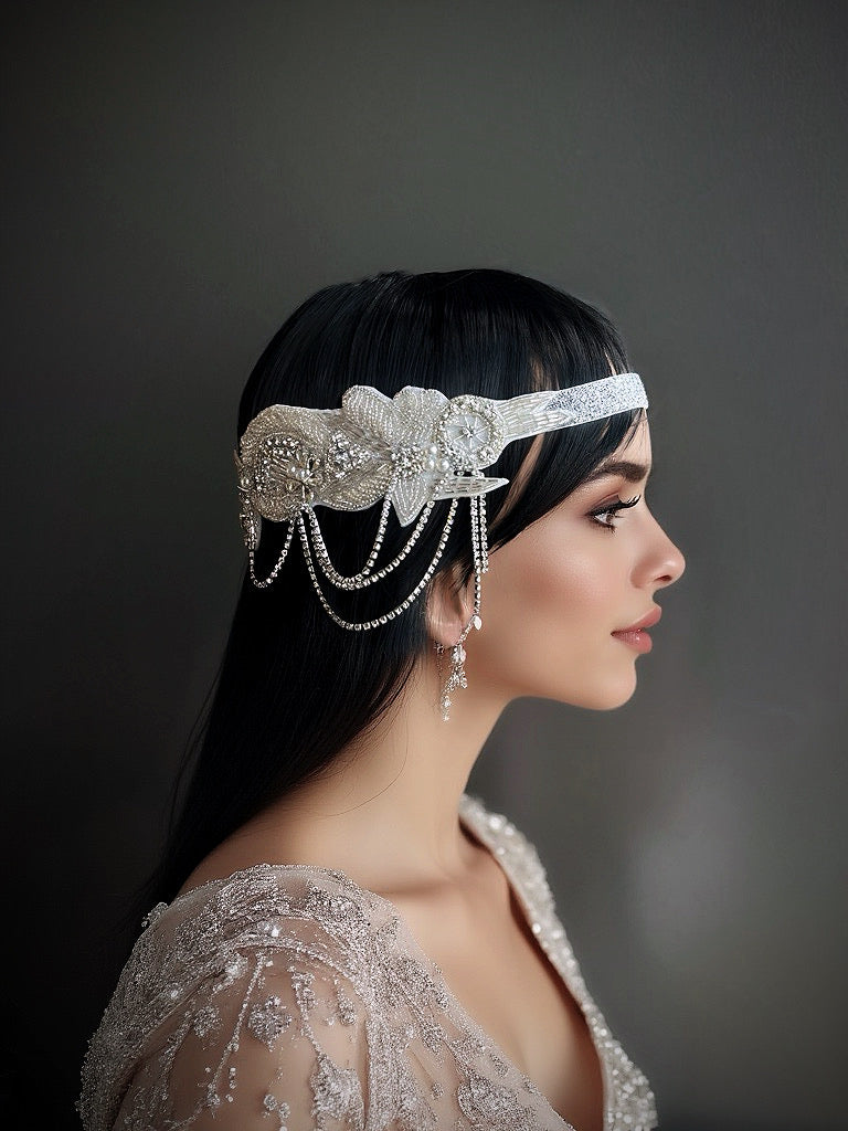 Silver headband with floral rhinestone design and cascading pearl drapes, perfect for weddings and formal events.

