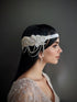 Silver headband with floral rhinestone design and cascading pearl drapes, perfect for weddings and formal events.

