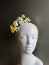 Floral fascinator with yellow and white flowers on a soft headband, ideal for spring and garden events.