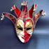 Venetian jester mask in red and gold with intricate gold filigree and jester points adorned with bells