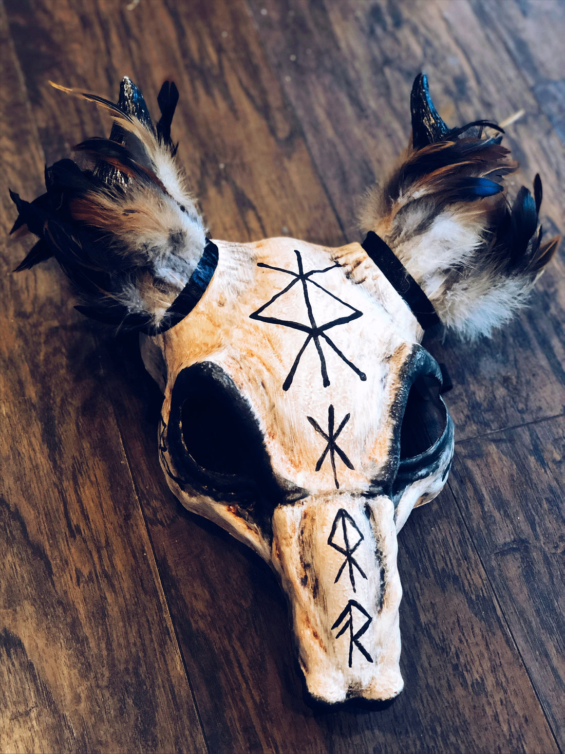 Viking rune short-horn headdress with aged bone textures and rustic feather details.