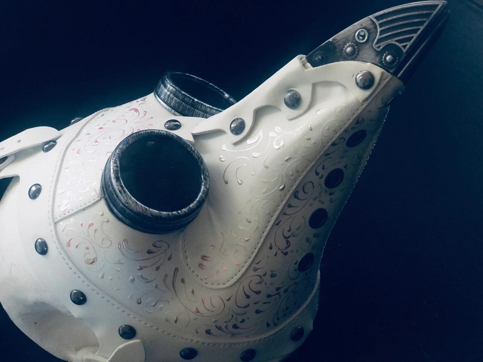 White steampunk plague mask with filigree detailing, rivets, and vintage goggles, perfect for Halloween or steampunk events.