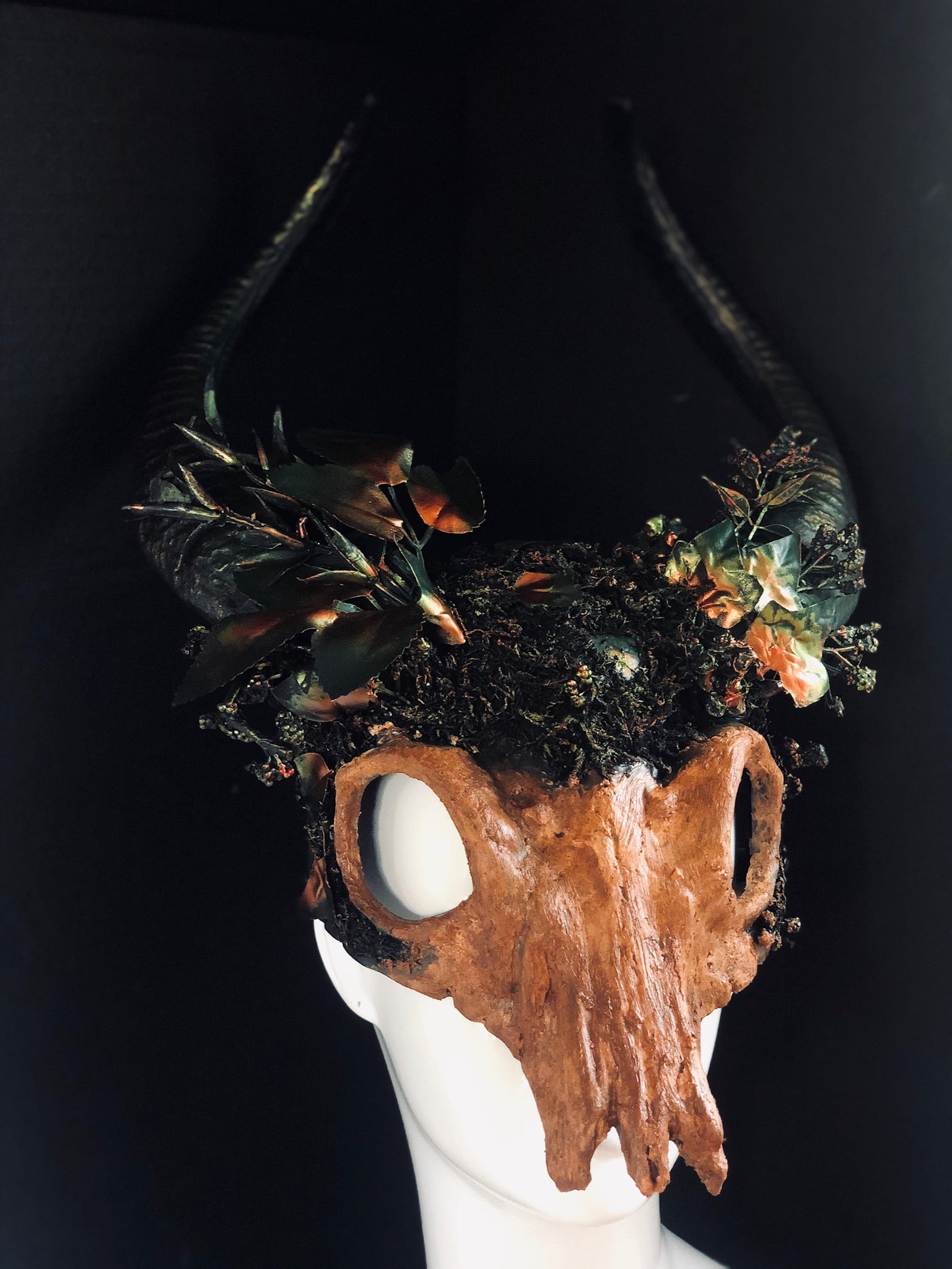 Wiccan skull headdress with horns, moss, and earthy embellishments, representing the Horned God for pagan rituals and spiritual traditions.